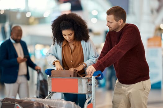 Travel, airport and interracial couple search for ticket. boarding passport and ID documents in luggage. Plane transport, dating and man and black woman check in suitcase, trolley and wait for flight.