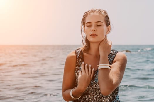 Woman travel sea. Young Happy woman in a long red dress posing on a beach near the sea on background of volcanic rocks, like in Iceland, sharing travel adventure journey