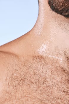 Water drops, wet torso and closeup man in shower for cleaning, care and wellness on background. Beauty, human body and hairy chest in studio for washing, grooming and hygiene cosmetics for skincare.