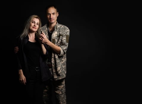 Happy woman hugging his husband came back from army. Smiling cheerful caucasian girlfriend embracing a soldier