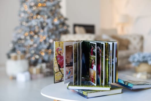 Photo book album under the Christmas tree surrounded by Christmas gifts.