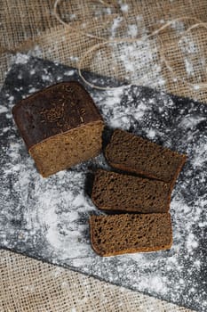 Slices of whole grain rye fresh bread on a dark background close up. Fresh home-baked sourdough bread