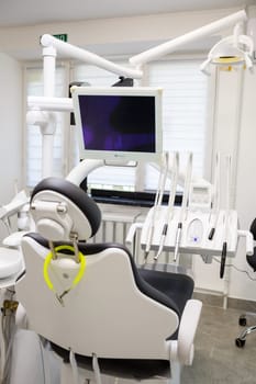 A modern dental office with new equipment and a dental chair. Cabinet for dental treatment. High quality photo