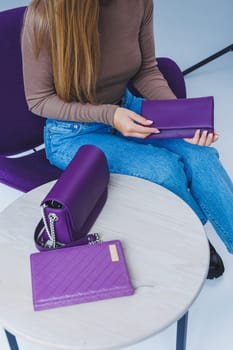 A purple leather bag in a girl's hand. Woman with luxury bag.