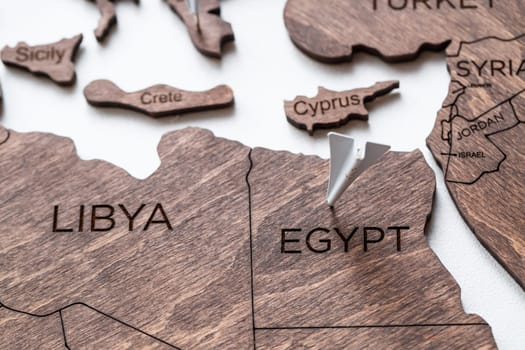 A wooden map of the world is glued to the wall on it marks with countries that have visited