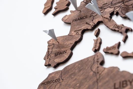 A wooden map of the world is glued to the wall on it marks with countries that have visited