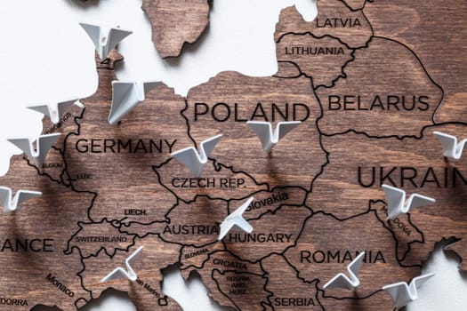 A wooden map of the world is glued to the wall on it marks with countries that have visited