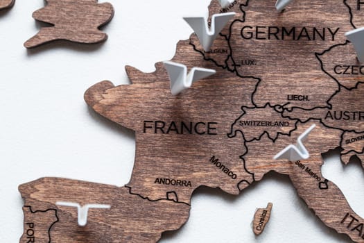 A wooden map of the world is glued to the wall on it marks with countries that have visited