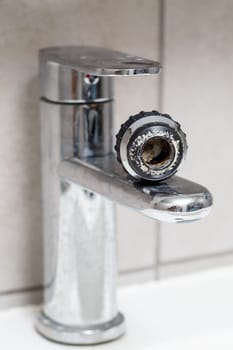 Broken tap in the bathroom sink. Splashing water from a silver faucet. Selective focus