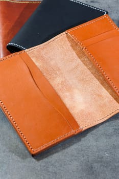 Black leather cardholder on a gray background. Handmade leather products.