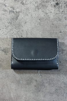 Black leather cardholder on a gray background. Handmade leather products.