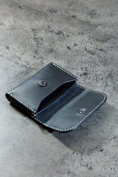 Black leather cardholder on a gray background. Handmade leather products.