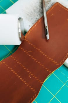 Tools for making leather goods and pieces of brown leather. Production of leather products. View from above