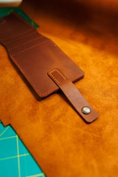 The process of production of leather goods. Materials and tools for leather production. Beautiful brown leather products and tools for needlework.