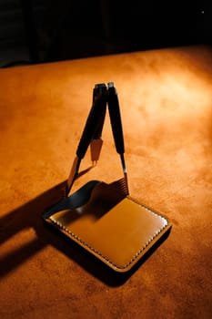Tools for making leather goods and pieces of brown leather. Production of leather products. View from above