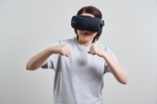 Happy young woman playing on VR glasses indoor. Virtual reality concept with young girl having fun with headset goggles.