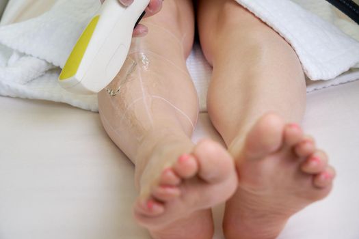Female legs, woman in professional beauty clinic during laser hair removal