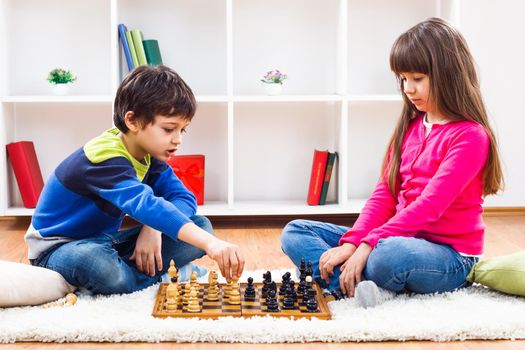 Image of children playing chess at home.