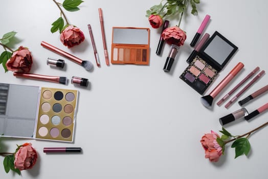 Decorative flat lay composition with cosmetics and flowers. Flat lay, top view on white background