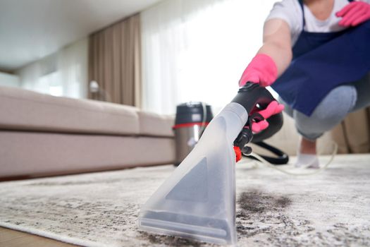 Close-up Of A Person Cleaning Carpet With Vacuum Cleaner