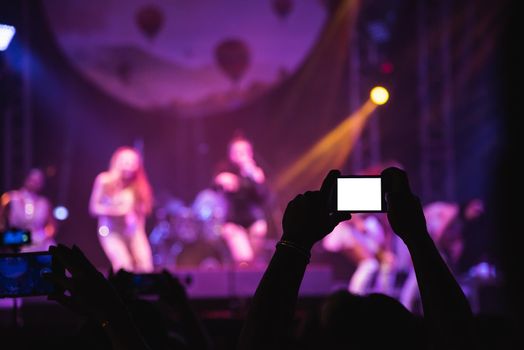 people shooting video or photo at concert