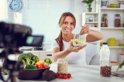 Attractive fitness girl keeping her daily blog and telling her followers how to be fit while eating healthy.