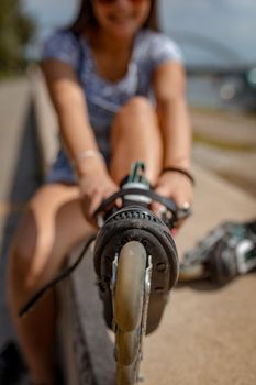 Close-up of a young woman preparing for roller skating.