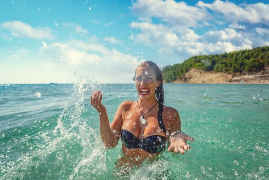 Beautiful young woman having fun and enjoying in the sea, on the beach. 