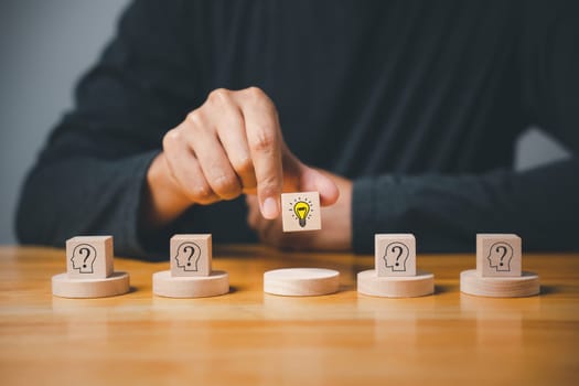 Creative consulting and innovative ideas. Wooden cubes with light bulb on hand icon. Business strategy suggestion for new initiative. Success through imagination and expertise.