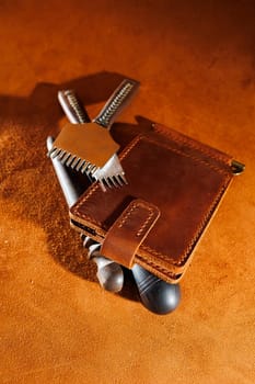 Production of handicrafts from genuine leather. Tools for making leather goods and pieces of brown leather. Production of leather products. View from above