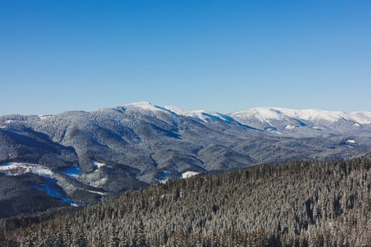Winter landscape of snowy mountains with winter forest. Winter landscape