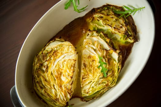 Young early cabbage baked in pieces in the oven, in a ceramic form.