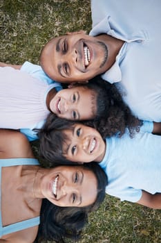 Family, portrait and lying on grass in garden with mother, father and kids together with love. Face, top view and dad with mom and children with parent support and care on a lawn with happy smile.