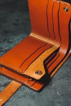 Stylish handmade brown leather men's wallet on a gray background. Product made of genuine leather.