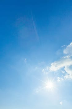 Blue sky with white clouds and shiny sun