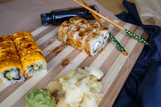 Set of traditional Japanese dishes. Sushi rolls, nigiri, raw salmon, rice, cream cheese, avocado, pickled ginger.