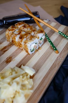 Sushi set with different types of rolls and sashimi made from eel, salmon, tuna, shrimp, red caviar and tobiko flying fish roe. Pan-Asian and Asian food and dishes on a black concrete kitchen table.