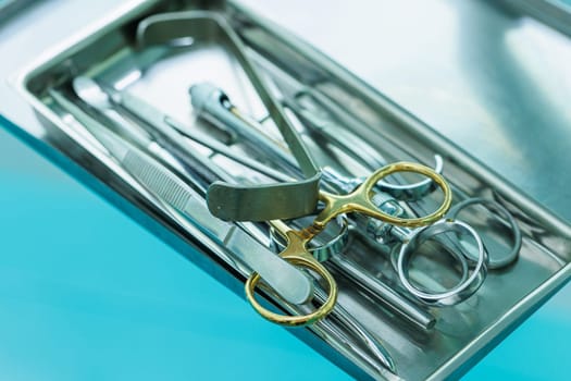 Tray with metal dental tools. Tools of the dentist. Interior of a patient reception room with dental equipment in a dental clinic.