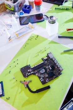 Professional computer and tablet repair shop or service. Close up of a computer board. Electronics concept. Detail from a laptop under repair