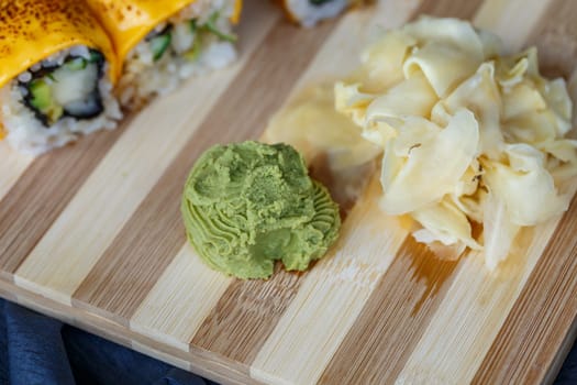 Sushi set with different types of rolls and sashimi made from eel, salmon, tuna, shrimp, red caviar and tobiko flying fish roe. Pan-Asian and Asian food and dishes on a black concrete kitchen table.