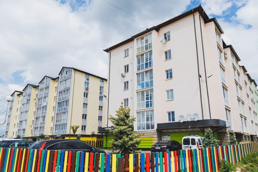 New-constructed unfinished multi-storey residential building. multi-storey residential house in brown and beige colors. Modern residential construction. Residential fund. Building on background of sky