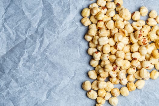 Delicious fried crispy hazelnuts lies in a heap, nuts close-up.
