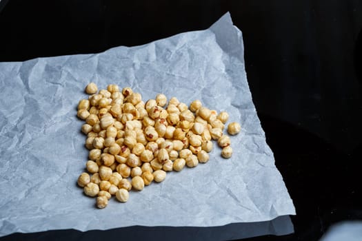 Delicious fried crispy hazelnuts lies in a heap, nuts close-up.