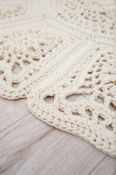 Handmade carpet knitted from natural threads, flooring, natural cotton. Beige handmade carpet. Knitted decorative item