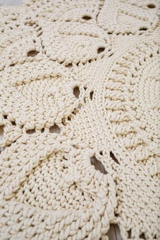 Handmade carpet knitted from natural threads, flooring, natural cotton. Beige handmade carpet. Knitted decorative item