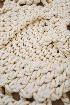 Handmade carpet knitted from natural threads, flooring, natural cotton. Beige handmade carpet. Knitted decorative item