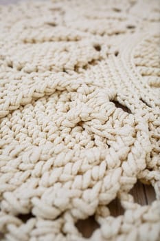 Handmade carpet knitted from natural threads, flooring, natural cotton. Beige handmade carpet. Knitted decorative item