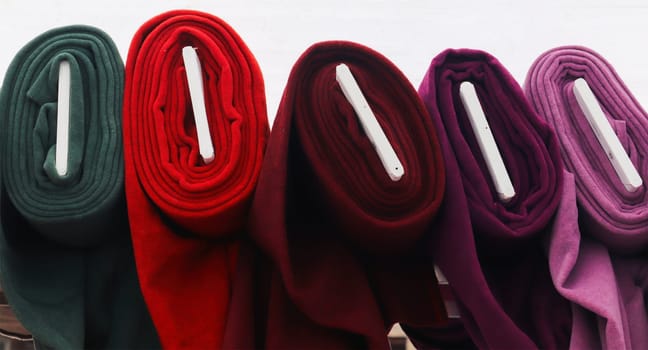 Detailed close up view on samples of cloth and fabrics in different colors found at a fabrics market.