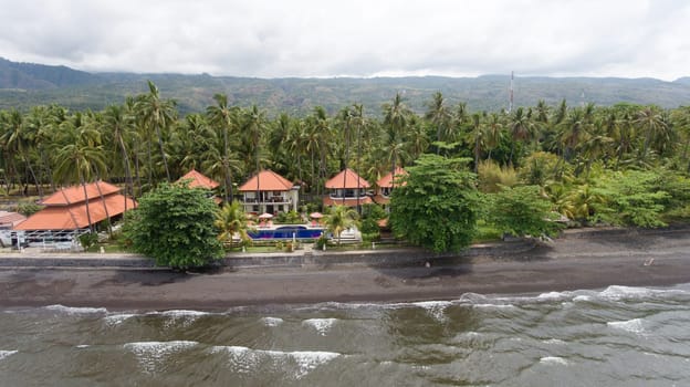 Aerial view of beautiful beach, hotel, Bali, Indonesia. Beach with black volcanic sand.Seascape ocean, sky, sea. 4K video Travel concept, Aerial footage.