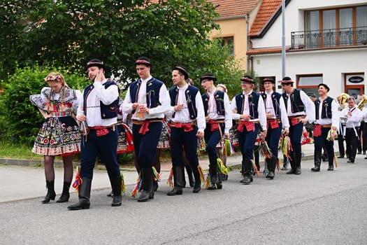 Brno - Bystrc, Czech Republic, 24 June, 2023. Traditional festivities of the feast of the feast in the Czech Republic. Food and drink festival. Girls and boys dancing in beautiful colourful traditional costumes. An old Czech custom of celebrating in villages. 